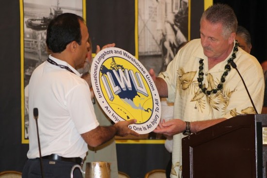 ILWU International President Robert McEllrath and Panama Canal Pilots Union officer Rainiero Salas view the ILWU logo at the 2012 ILWU Convention in San Diego, June 2012. Panama has been included in the logo in solidarity with the U.S. and Canada with the new affiliation of the Panama Pilots union with the ILWU. Photo by Lewis Wright.